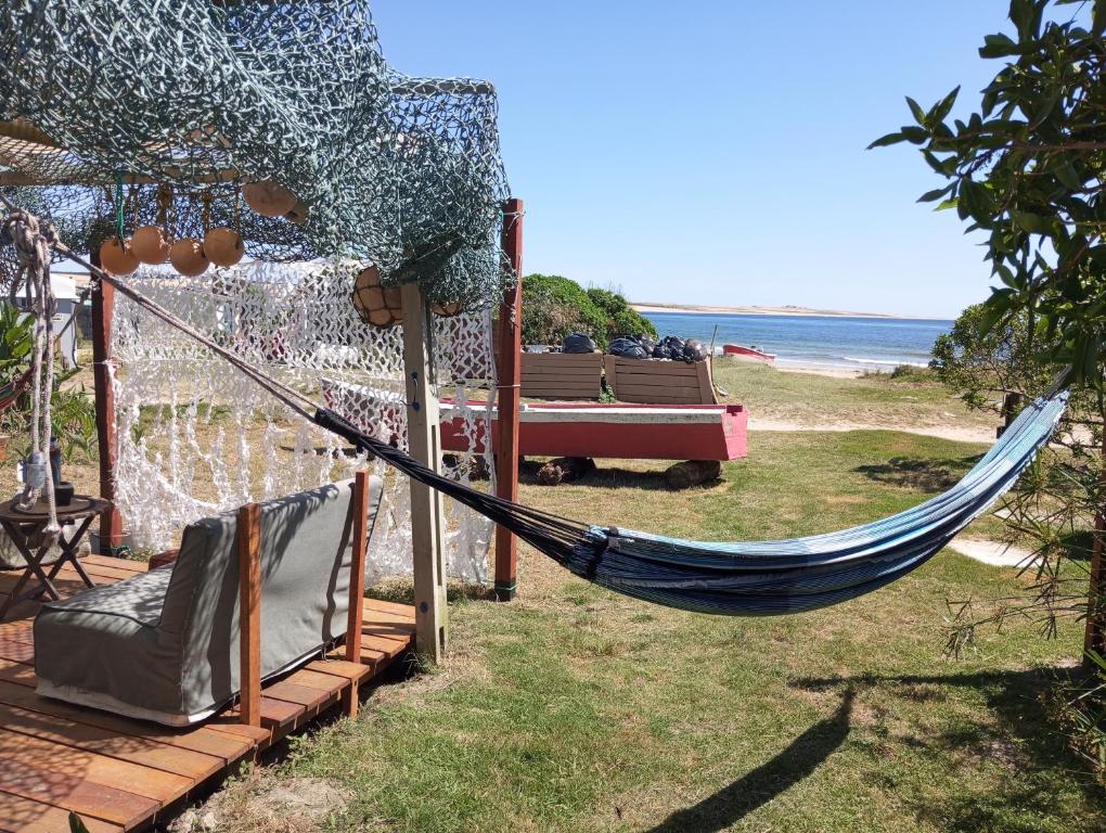 a hammock in a yard next to the beach at El Navegante in Cabo Polonio