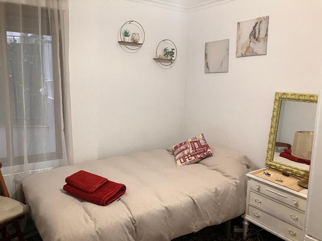 薩拉戈薩的住宿－Disfruta tu estancia en Zaragoza!，一间小卧室,配有一张带镜子的床