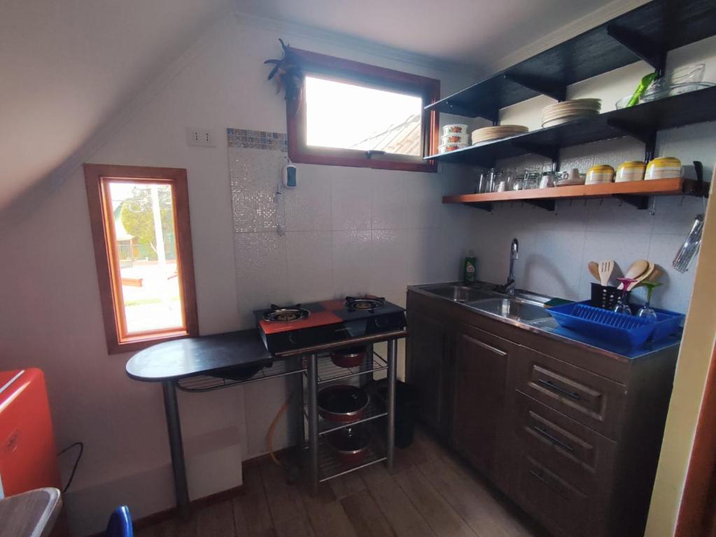 eine kleine Küche mit einer Spüle und einer Theke in der Unterkunft Acogedor departamento interior con acceso independiente y estacionamiento in La Serena