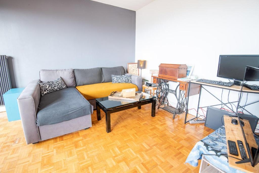 - un salon avec un canapé et un bureau avec un ordinateur dans l'établissement Le Botanique - Joli appart à Tours, à Tours
