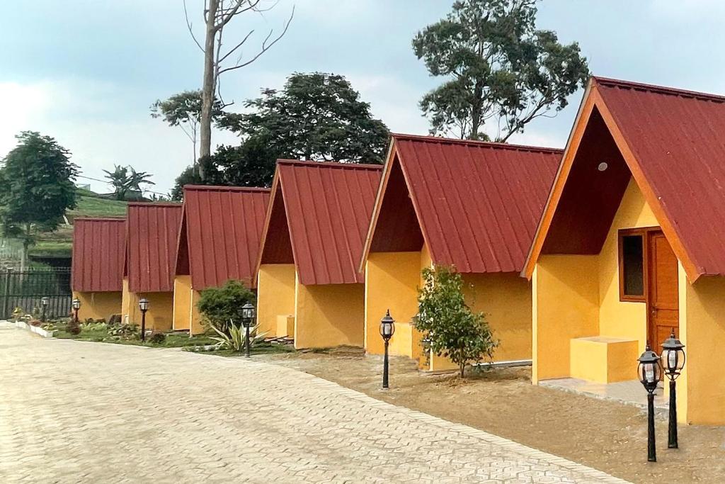 una fila de edificios con techos rojos en una carretera en Urbanview Hotel Nerine's Glamping Village Cipanas by RedDoorz, en Barukupa