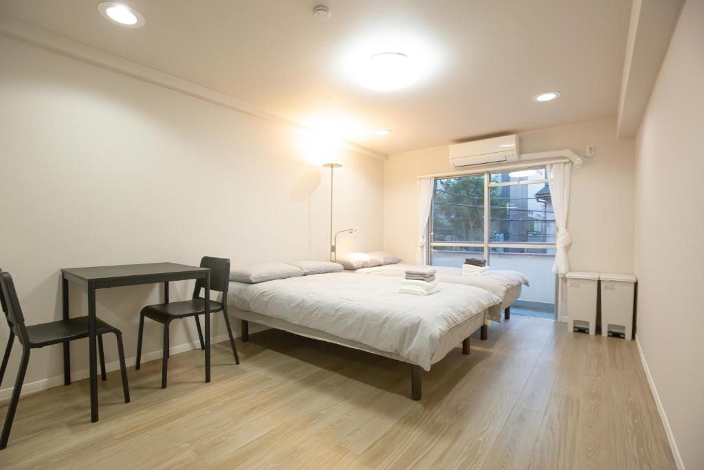 a room with two beds and a table and a window at walk to JR Yoyogi sta.-DSYE in Tokyo