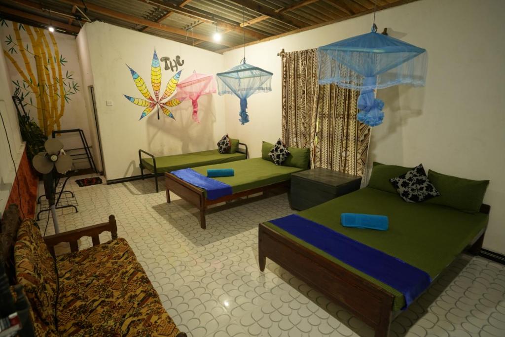 un soggiorno con 2 letti e un divano di Habarana magical hostel a Habarana