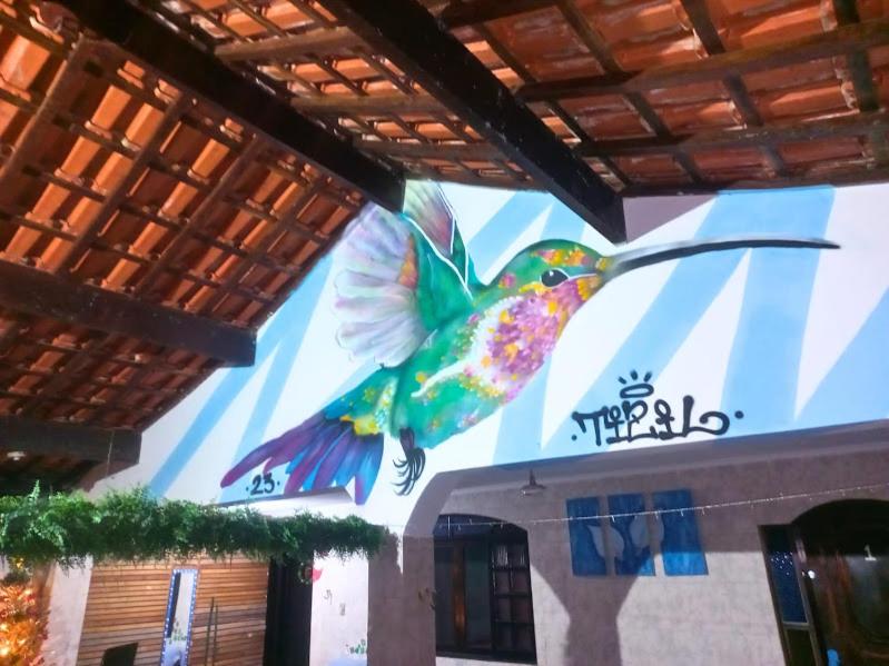a painting of a humming bird on the side of a building at Hostel do Valdemar in Praia Grande