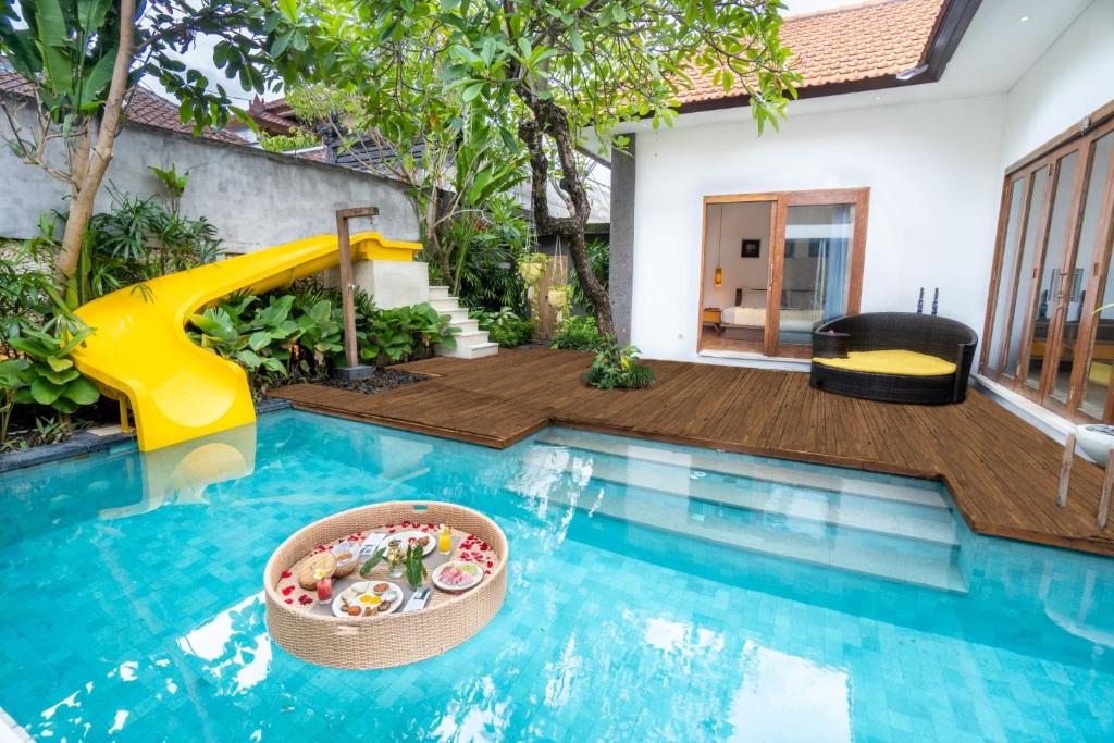 a swimming pool with a slide in a house at La Mira Villa Seminyak by Ini Vie Hospitality in Kerobokan