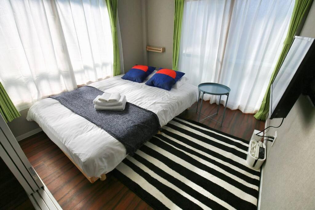 1 dormitorio con 1 cama con almohadas azules y rojas en Edogawa Japanese Style Apartment 302 has direct access to Akihabara and Shinjuku, with convenient transportation and free WiFi, en Tokio