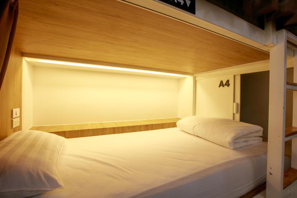 a bed in a room with a large white bed at Lafami Hostel in Ban Nongdouang