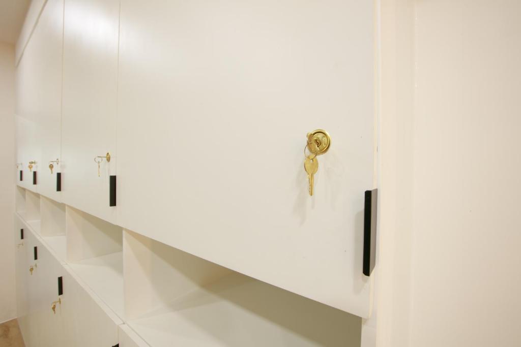 a white locker with a door with a key on it at Lafami Hostel in Ban Nongdouang