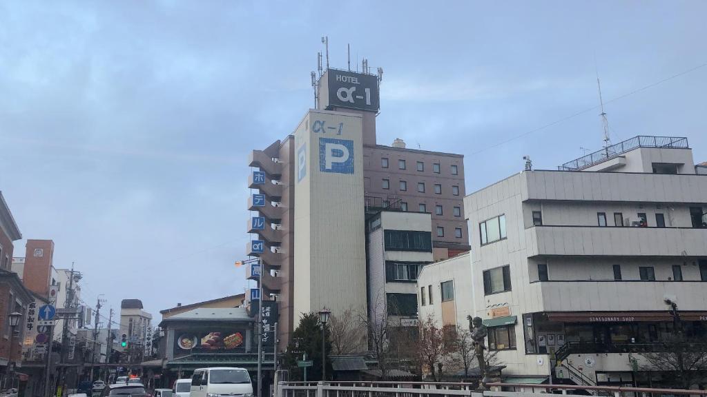 wysoki budynek z wieżą zegarową w mieście w obiekcie Hotel Alpha-One Takayama w mieście Takayama