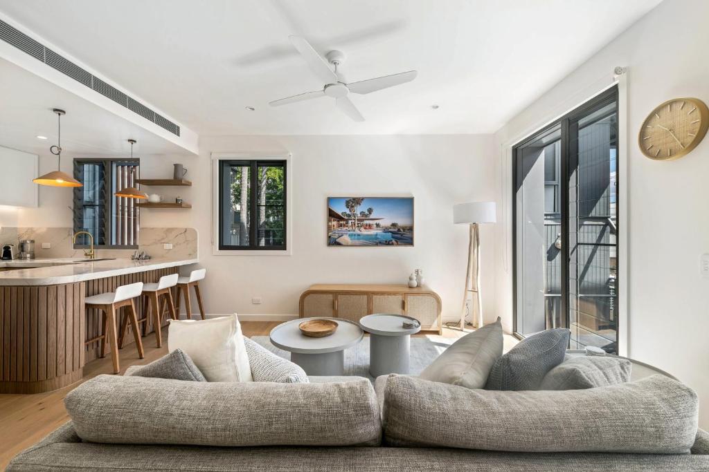 una sala de estar con un sofá y una mesa en Luxury Retreat New Villa 17, Hastings St, en Noosa Heads