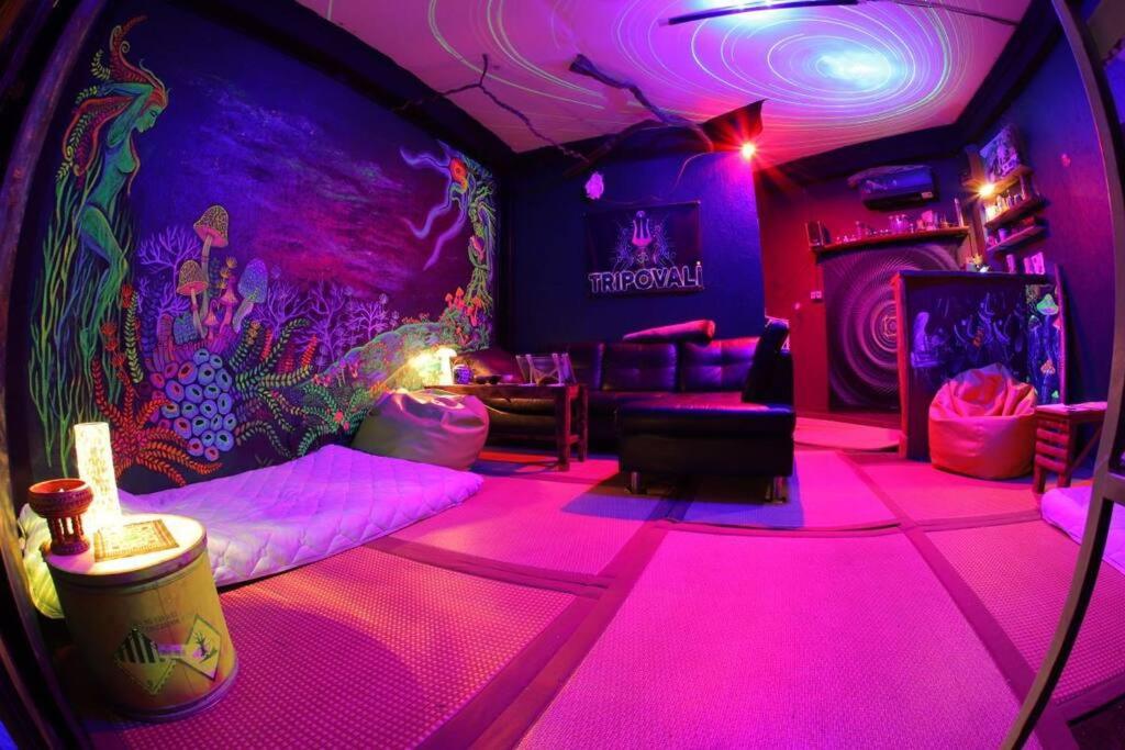 una camera con luci rosa e una camera con divano di Tripovali Guesthouse a Ko Phangan