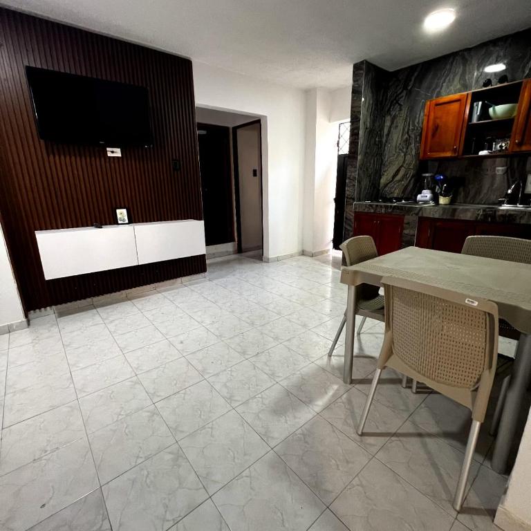 a living room with a table and a tv at Apartamentos San José in Cartagena de Indias
