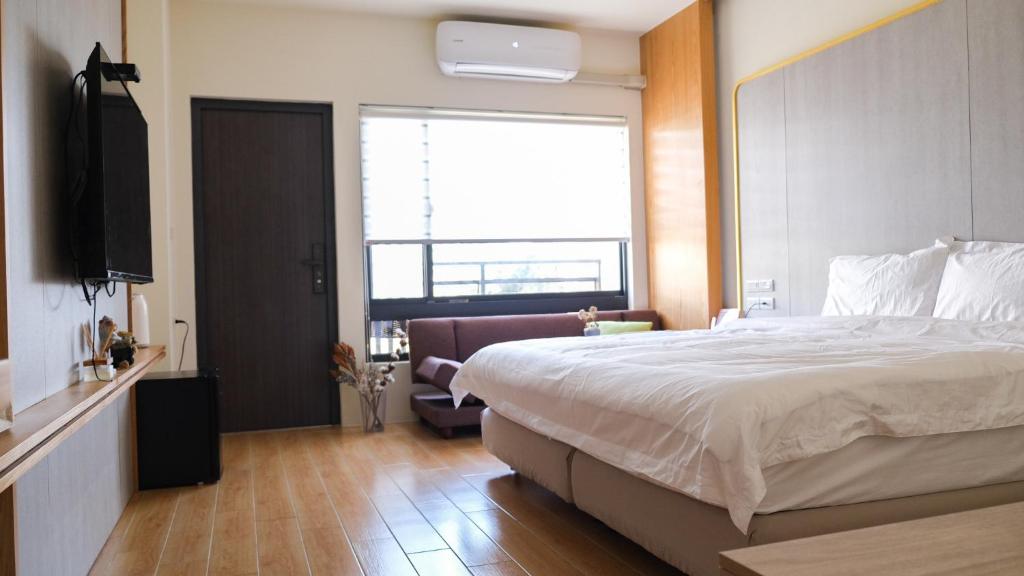 a bedroom with a large bed and a television at Moker House B&B in Jincheng