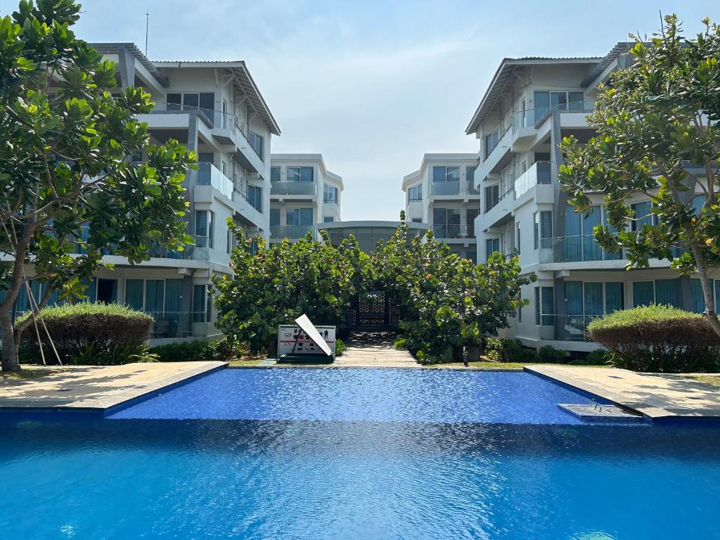 a swimming pool in front of some apartment buildings at Apartment314 Oceanfront condos Nilaveli in Trincomalee