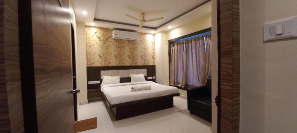 a bedroom with a bed and a door to a room at Goroomgo Hotel Home Town Near Golden Beach Puri in Puri