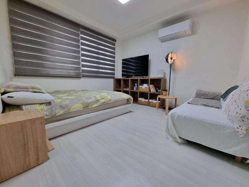 1 Schlafzimmer mit 2 Betten und einem Flachbild-TV in der Unterkunft Miz Soo House in Seoul