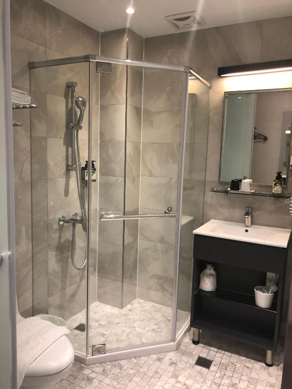 a bathroom with a glass shower and a sink at Cityinn Hotel Taipei Station Branch I in Taipei