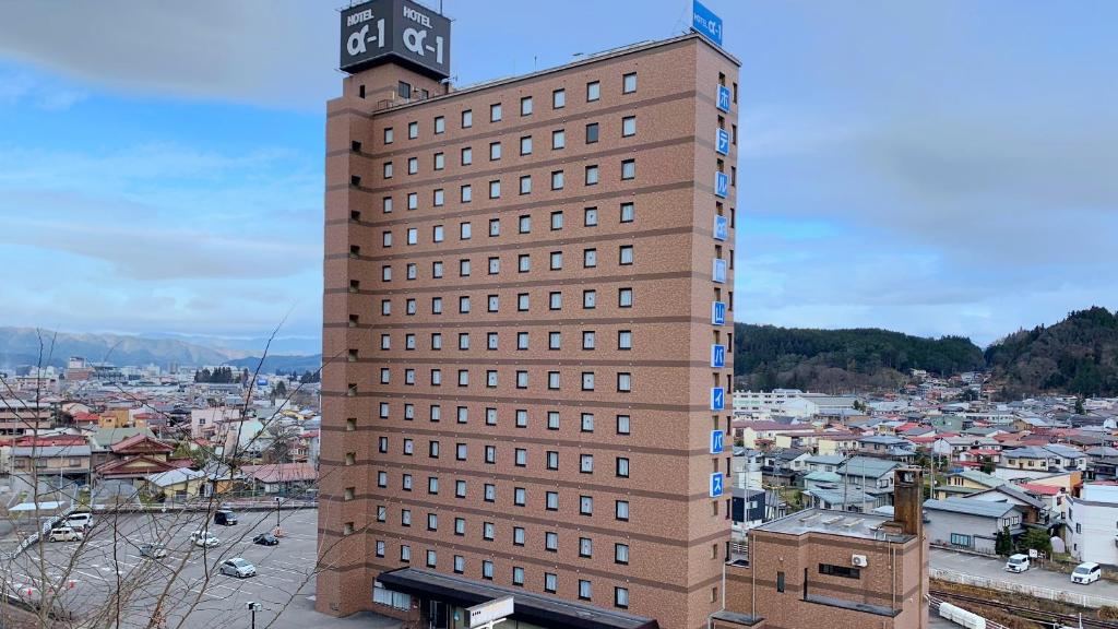 un grand bâtiment avec une tour d'horloge en haut dans l'établissement Hotel Alpha-One Takayama Bypass, à Takayama