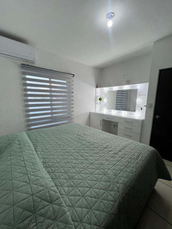 a bedroom with a bed with a green comforter at Casa valle oriente in Saltillo