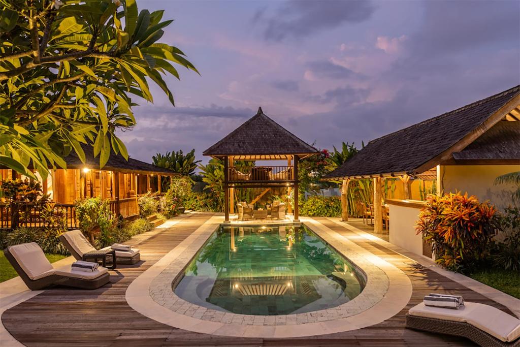 a swimming pool in a backyard with a gazebo at Villa Lina by Optimum Bali Villas in Canggu