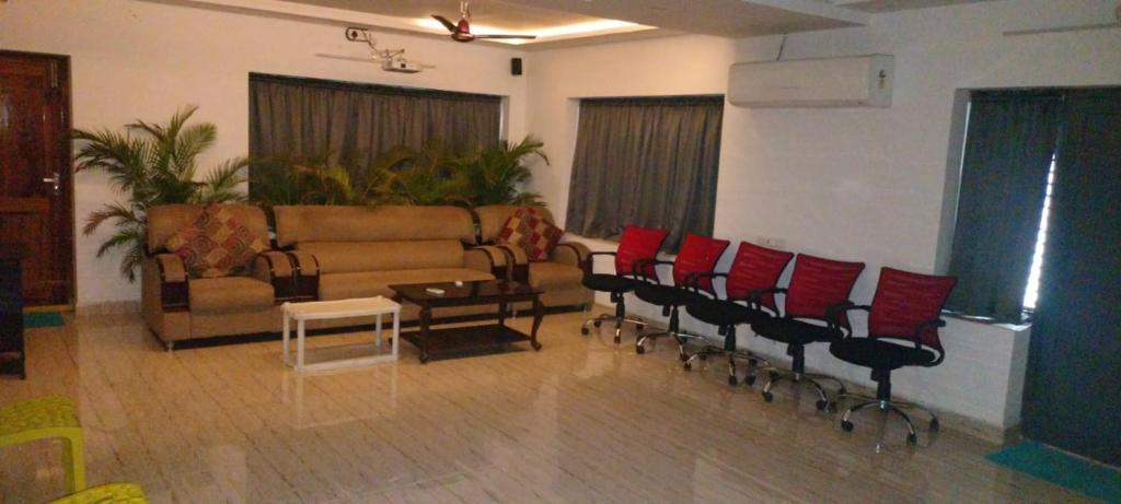 a living room with a couch and red chairs at INDEPENDENT PEACE FULL GUAST HOUSE in Tanuku