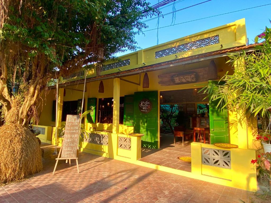 un restaurante amarillo con un cartel delante en Elephant's House - Đường Lâm Homestay en Hanói