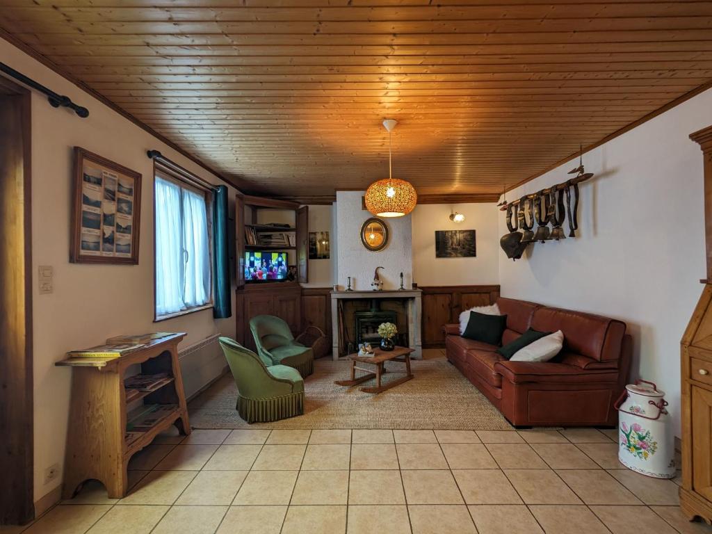 a living room with a couch and a fireplace at Maison Vosgienne Charmante: 2 Chambres, Cheminée, Proche Gérardmer, Parfaite pour Familles et Fêtes - FR-1-589-36 in Corcieux