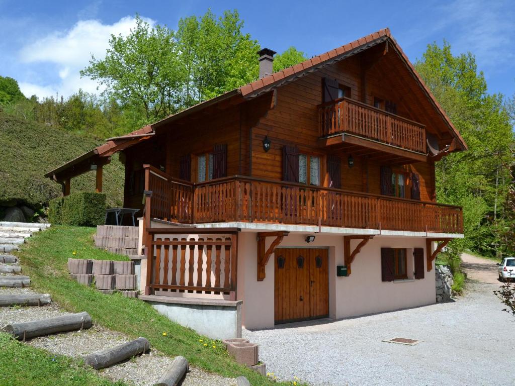 a large wooden house with a porch and a balcony at Gîte Le Menil, 5 pièces, 5 personnes - FR-1-589-107 in Le Ménil