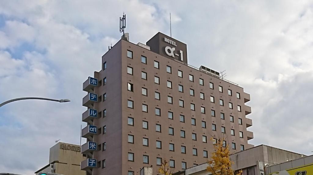 a building with a flag on the top of it at Hotel Alpha-One Yonago in Yonago