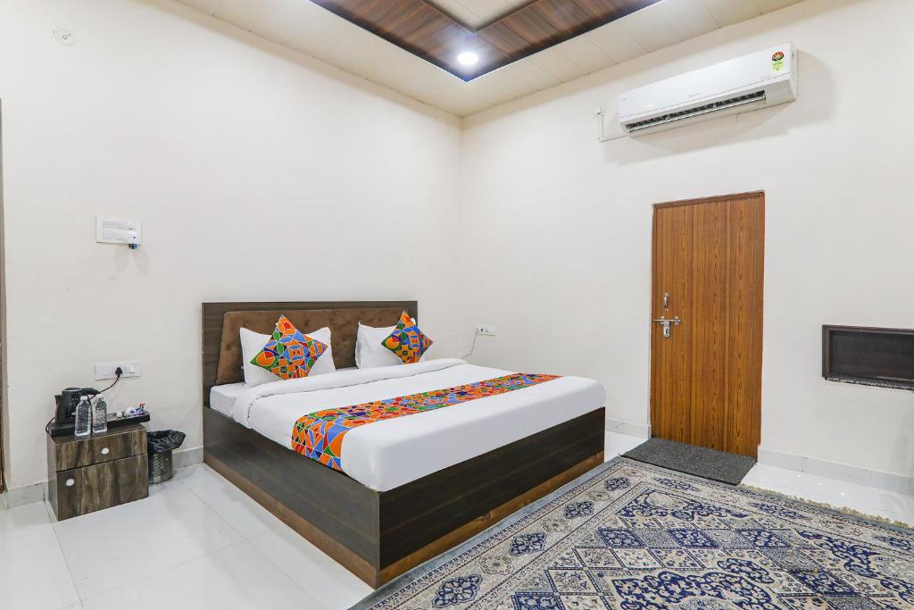 a bedroom with a bed and a wooden door at FabHotel Sarovar Palace in Muthiganj