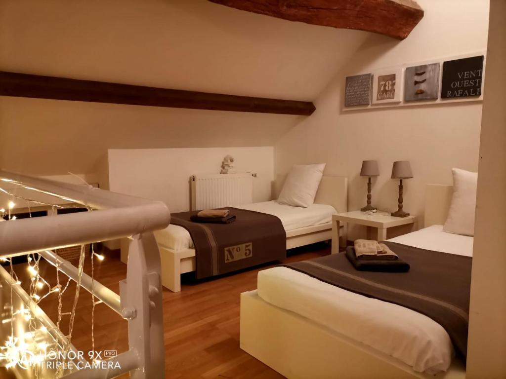 Port-sur-SaôneにあるLa petite maison de Marieのホテルルーム ベッド2台&階段付