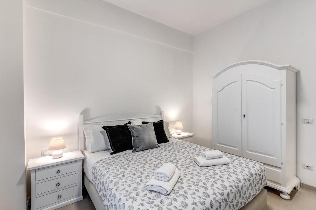 een witte slaapkamer met een bed met twee handdoeken erop bij PMT Apt in Rome