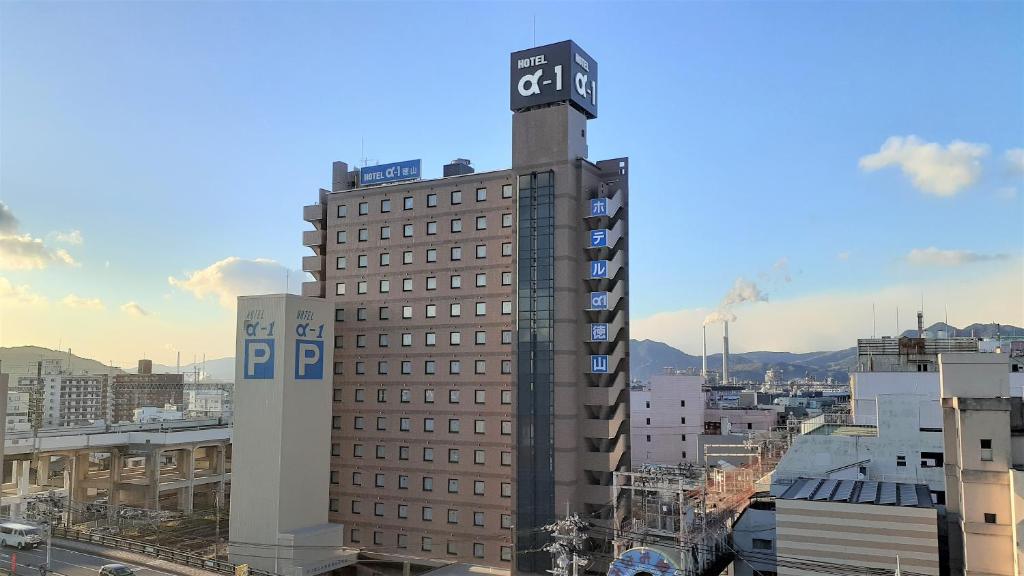 um edifício alto com uma torre de relógio em cima em Hotel Alpha-One Tokuyama em Shunan