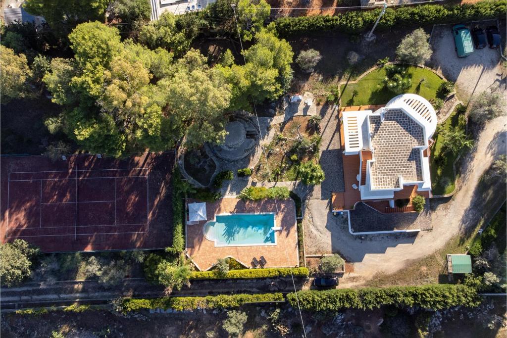een uitzicht op een huis met een zwembad bij Villa Menhir with pool garden and tennis - Happy Rentals in Tuglie
