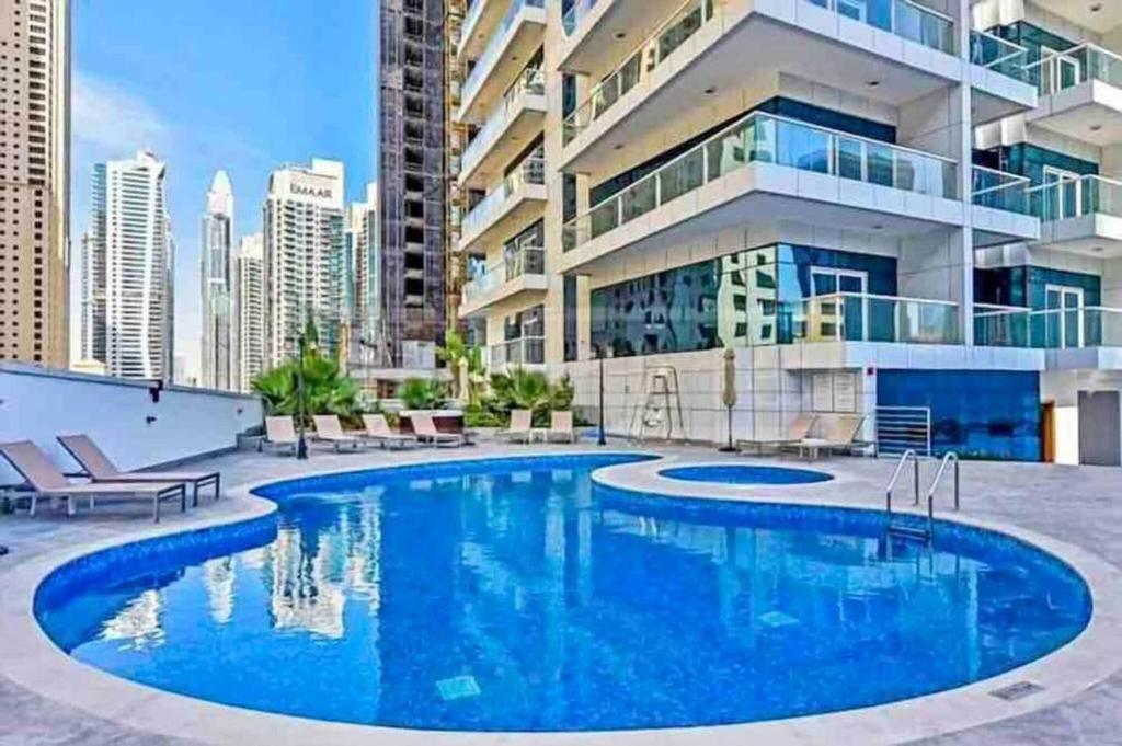 a large swimming pool in front of a building at Lux High Rise Marina Apartment in Dubai