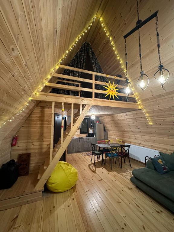 Großes Zimmer mit einer Holzdecke und einem Holztisch. in der Unterkunft Borjomi Story in Bordschomi