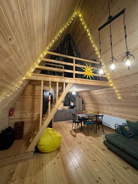 a large room with a wooden ceiling with a wooden table at Borjomi Story in Borjomi