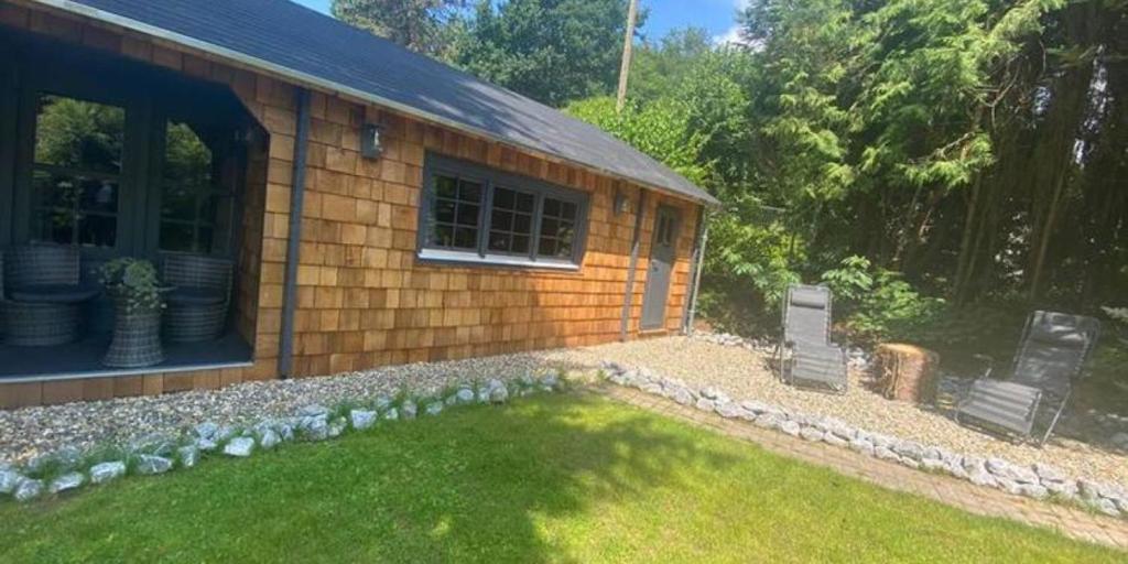 Una casa con dos sillas en el patio. en Weißenthalsmühle Eichenhäuschen, en Ermetheis