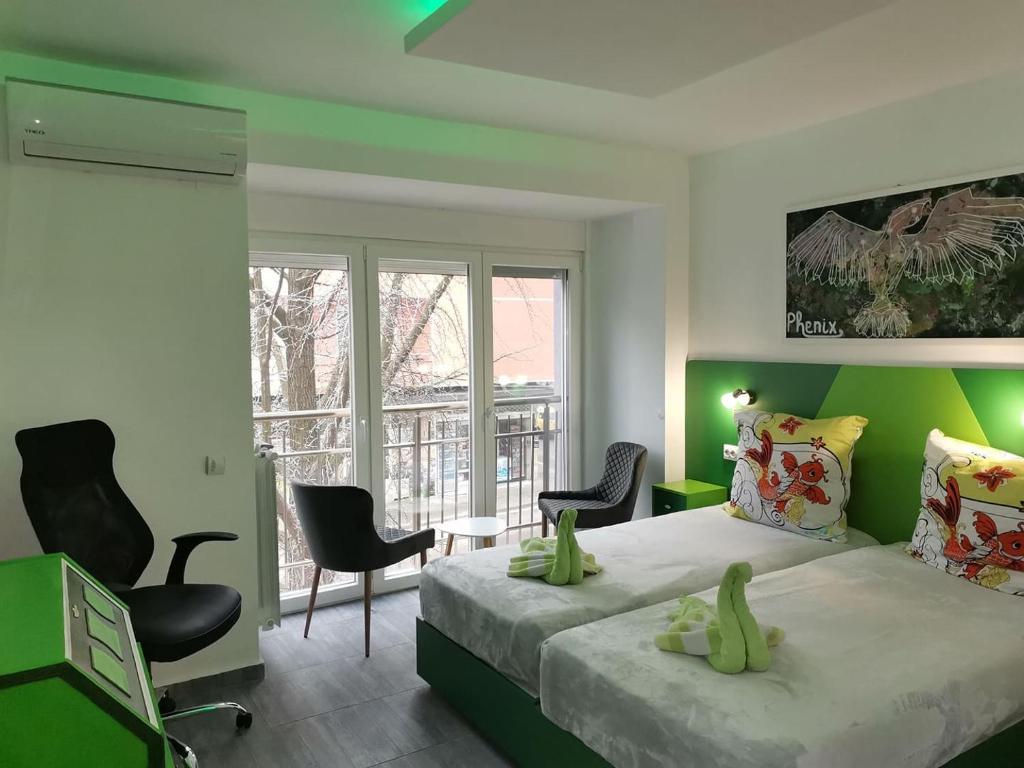 een slaapkamer met een bed met groene muren en stoelen bij Бутик хотел ресторант брасери Сажитариус in Kyustendil
