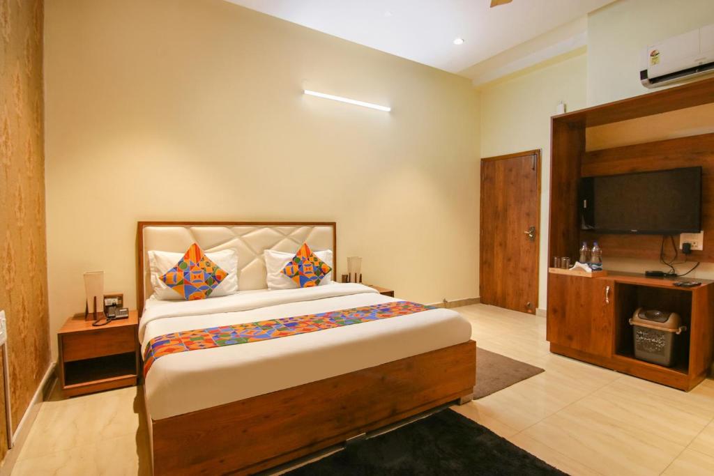 a bedroom with a large bed and a flat screen tv at FabHotel K9 Regency in Dorāha