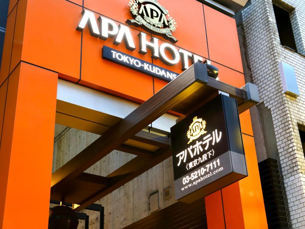 een bord aan de zijkant van een gebouw bij APA Hotel Tokyo Kudanshita in Tokyo