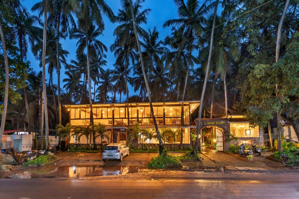 a house in the middle of palm trees at night at Le dando Beach Resort by Orion Hotels in Old Goa