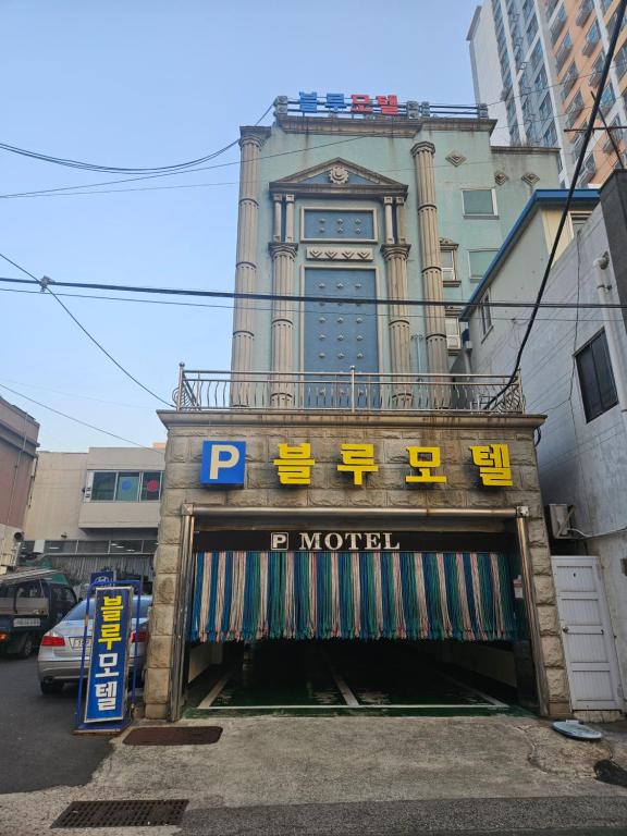 a building with a parking garage in front of it at Blue Motel in Busan