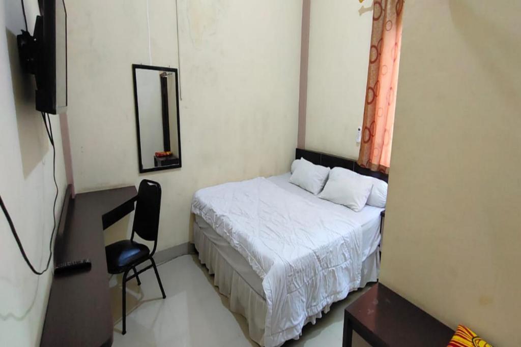 查亞普拉的住宿－OYO 93479 Hotel Jaguar Sentani，一间小卧室,配有一张床和一把椅子
