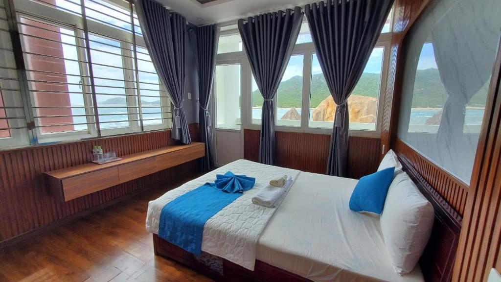 a bedroom with a bed with a blue bow on it at Khu du lịch Hang Rái - Ninh Thuận in Thôn Thái An
