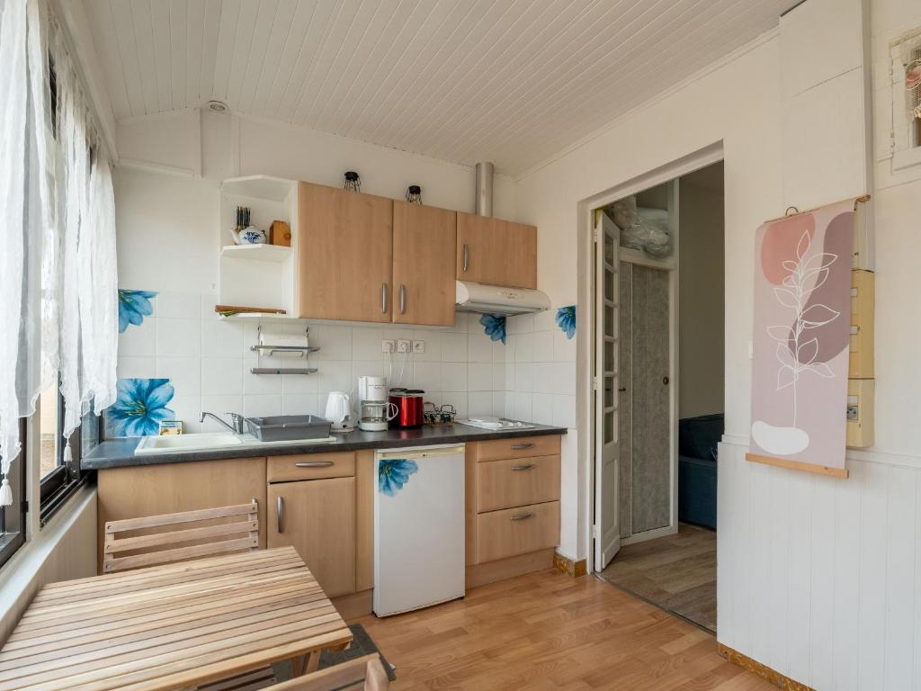 - une cuisine avec des placards en bois et un réfrigérateur blanc dans l&#39;établissement Appartement Mimizan, 1 pièce, 3 personnes - FR-1-50-123, à Mimizan