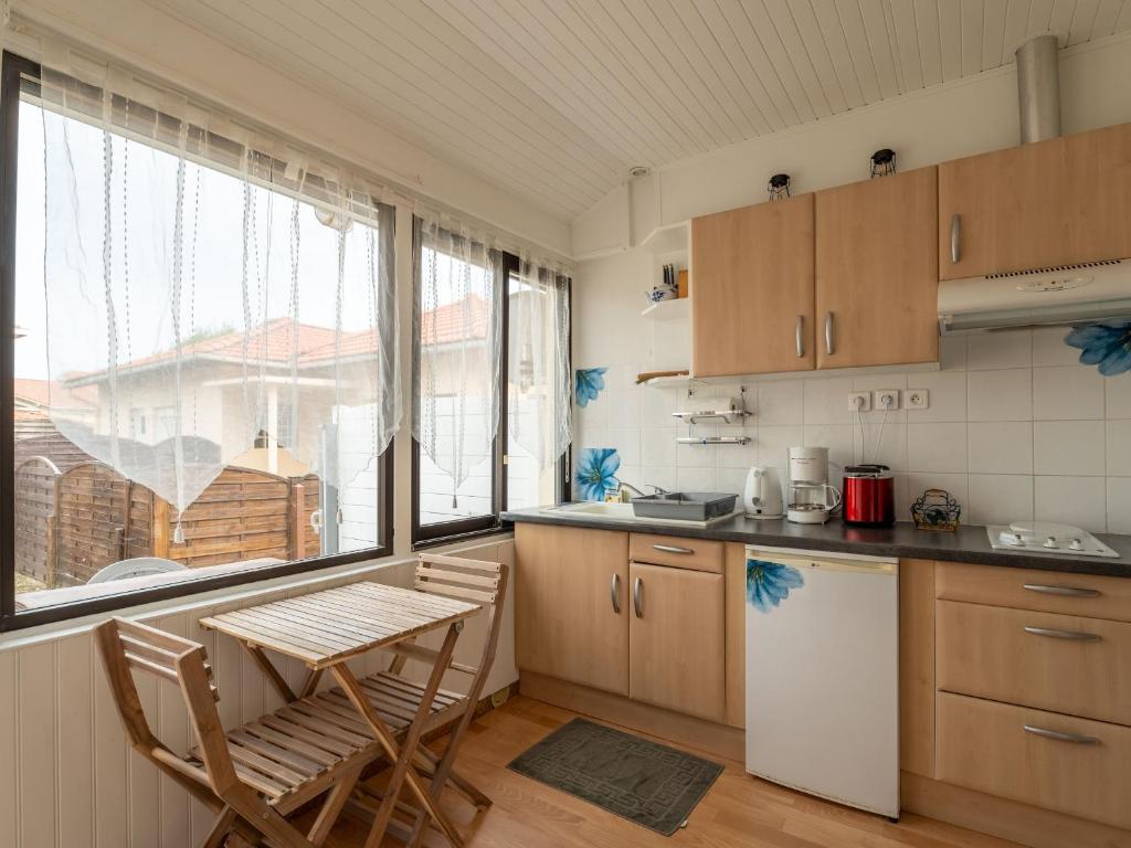 une cuisine avec des placards en bois, une table et une fenêtre dans l&#39;établissement Appartement Mimizan, 1 pièce, 3 personnes - FR-1-50-123, à Mimizan