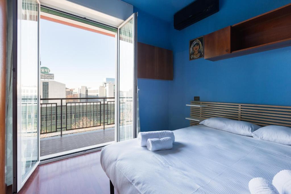 a blue bedroom with a bed and a large window at Roomy Apartment with Balcony! in Milan