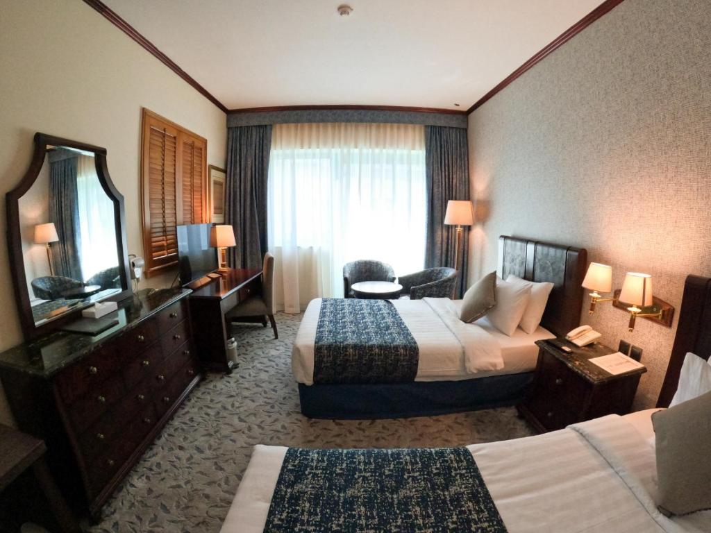 Knight Armour Hotel في دبي: غرفه فندقيه سريرين وتلفزيون