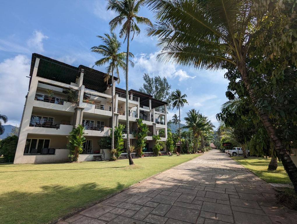 a building with palm trees in front of it at Seaview Apartment in Siam Royal View in Ban Khlong Son